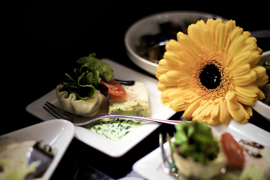Vorspeisen auf schönen weißen Tellern, ebenfalls dekoriert mit einer Blume