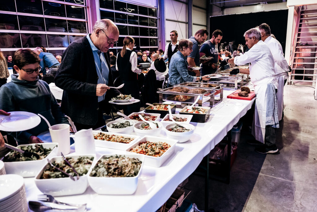 Das Buffet ist eröffnet unser Cateringteam versorgt die ersten Gäste am langen Tisch mit Salaten und Hauptspeisen.