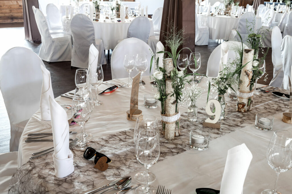 Eine toll dekorierte, runde Tafel, unser Feststadl is bereits für die kommende Hochzeit. Weiße Servietten, Weingläser alles steht bereit.