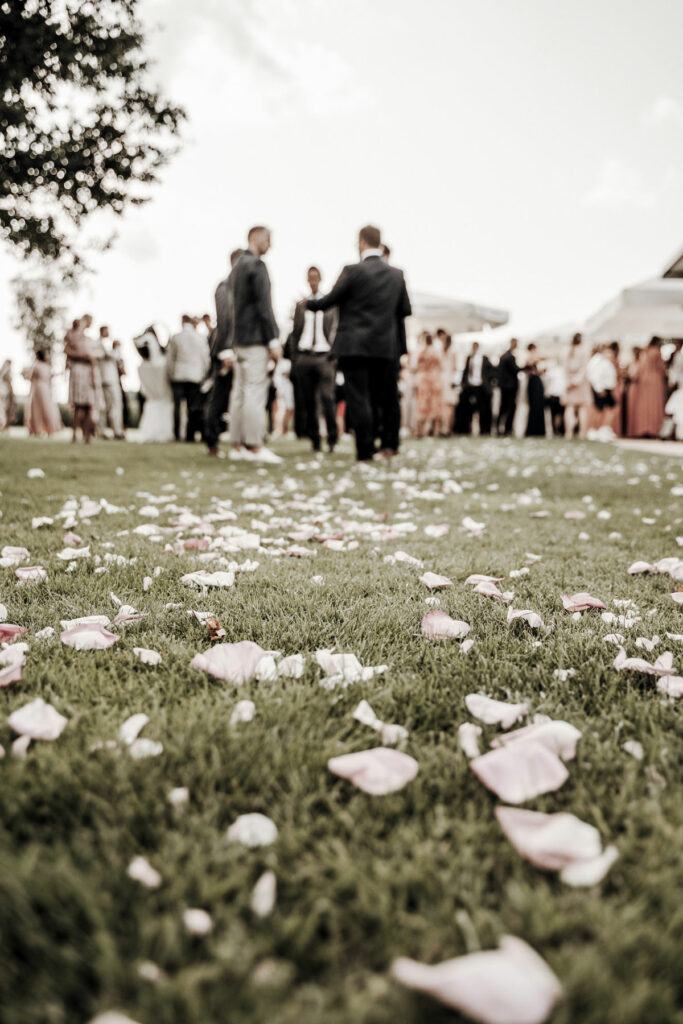 Eine Hochzeit bei uns in Günz im freien, Blumenschmuck auf dem Boden und eine Personengruppe im Hintergrund.