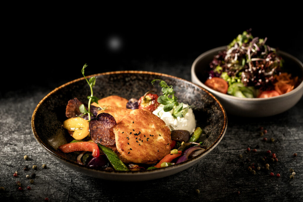 Kartoffelecken mit Salat und Burratta. Toll angerichtet und fotografiert auf dunklem Hintergrund.