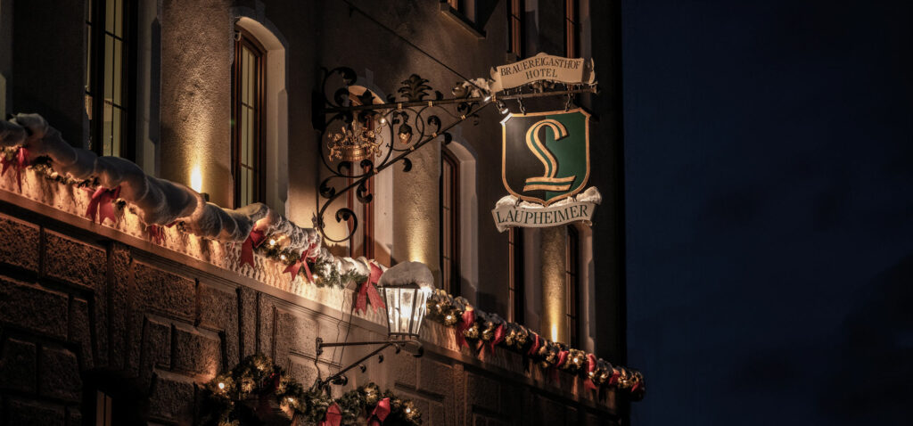 Unser toll dekoriertes Gasthaus im Winter, zu sehen das ausgeleuchtete Laupheiemer Wappen über dem Haupteingang.
