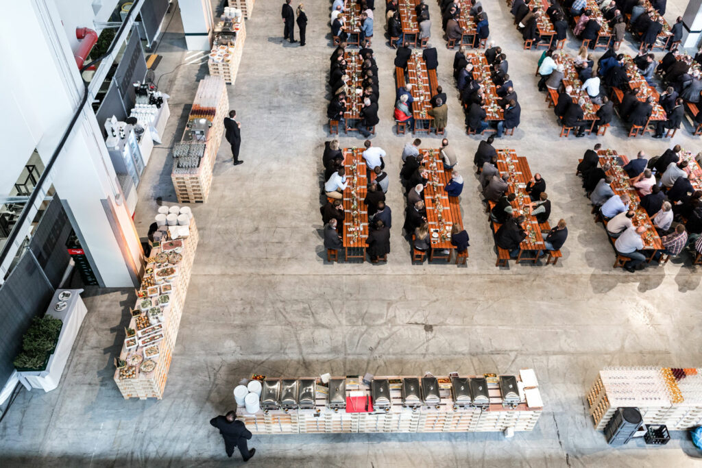 Ein Bild aus der Vogelperspektive beim Liebherr Firmenevent. Unser Buffet, die Getränke und die Tische inklusive der Mitarbeitern sind gefüllt und bereit.