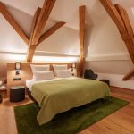 Stilvolles Doppelzimmer mit freigelegten Holzbalken im Brauereigasthof-Hotel Laupheimer in Günz im Allgäu, nahe Flughafen Memmingen – moderne Ausstattung und gemütliche Atmosphäre.